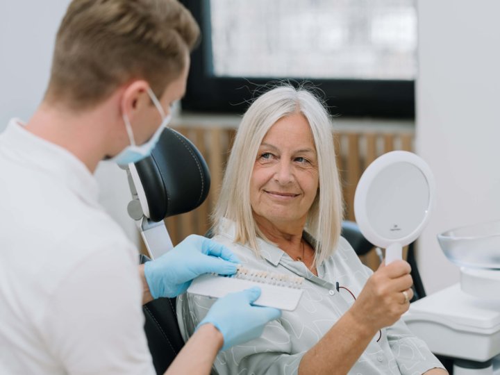 Zahnarzt berät Patientin im Behandlungszimmer
